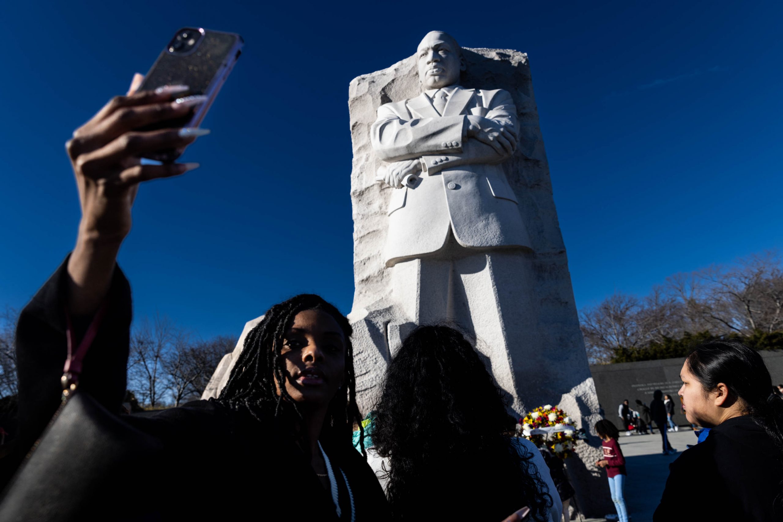 People gather and take pictures at the Martin Luther King Jr. Memorial on Martin Luther King Jr. Day in Washington, Monday, January 16, 2023.