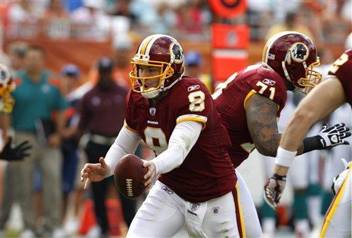 Washington Redskins quarterback Rex Grossman (8) hands off the football during the first quarter of an NFL football game against the Miami Dolphins, Sunday, Nov. 13, 2011, in Miami.