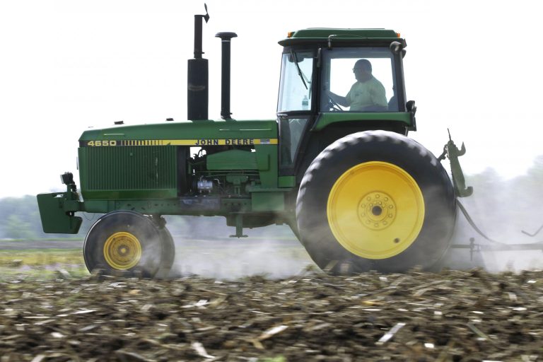 FILE - In this April 2, 2012 file photo, Derek Long uses a John Deere tractor to disk and cultivate a field in preparation for planting corn in Loami, Ill.  Deere & Co. reports quarterly earnings on Wednesday, Feb. 12, 2014. (AP Photo/Seth Perlman, File)