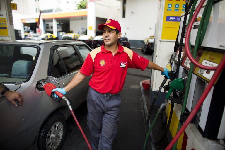 An attendant fills a tank at a Shell gas station in Buenos Aires, Argentina, Monday, Feb. 3, 2014. Shell increased prices an average of 12 percent. (AP Photo/Victor R. Caivano)