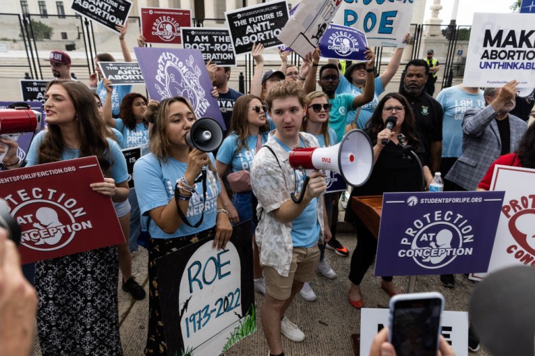 Anti-abortion rights supporters hold signs in favor of the overturning of Roe v. Wade on Friday in Washington.