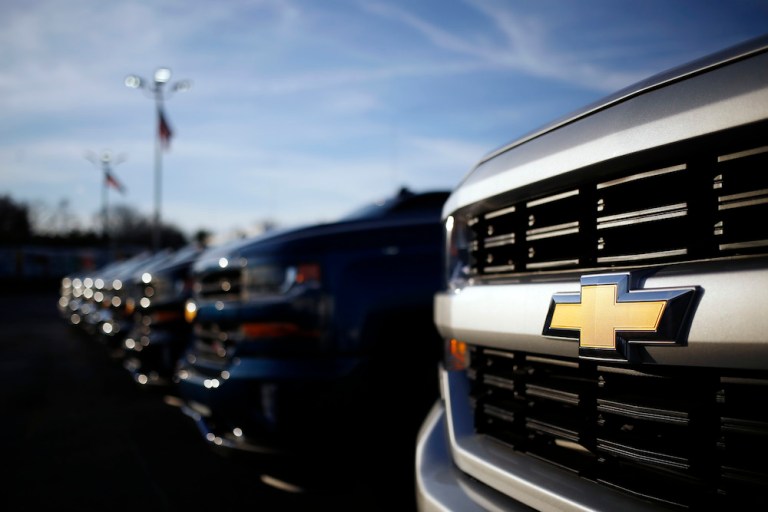 The Chevrolet logo, above, on the front of a pickup at a Louisville, Ky., car dealership. Carmakers like Chevy parent GM have strong enough credit to handle the strain of President Trump's proposed automotive tariffs, according to corporate ratings firm Fitch. 