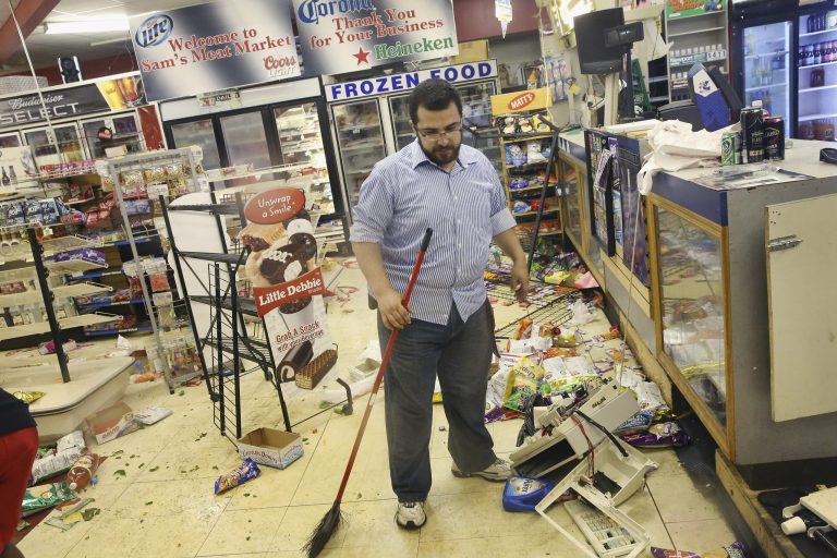 Business owner Mustafa Alshalabi cleans damage to his store after it was looted during another night of rioting in Ferguson, Missouri. (Getty images/ Scott Olson)