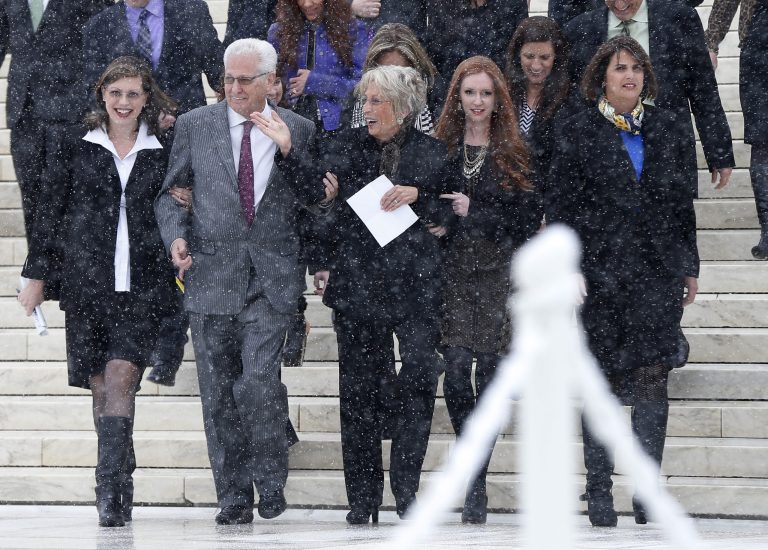 FILE - In this March 25, 2014 file photo, David Green, founder and chief executive officer of Hobby Lobby, second from left, walks with his wife Barbara, center, and members of their family as they acknowledge a cheer from demonstrators in the crowd as they descend the steps of the Supreme Court in Washington, after the court heard oral arguments in the challenges of President Barack Obama's health care law requirement that businesses provide their female employees with health insurance that includes access to contraceptives. The Monday, June 30, 2014 Supreme Court ruling that the Hobby Lobby crafts store chain does not have to provide all forms of birth control marks the first time the high court has said some businesses can hold religious views under federal law, in cases where there is essentially no difference between the business and its owners. (AP Photo/Charles Dharapak, File)