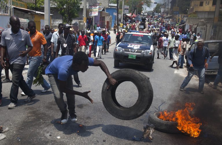 A protester burns tires on the street during a protest against President Michel Martelly's government in Port-au-Prince, Haiti, Tuesday April 15, 2014. Those demonstrating called for the resignation of  Martelly.( AP Photo/Dieu Nalio Chery)
