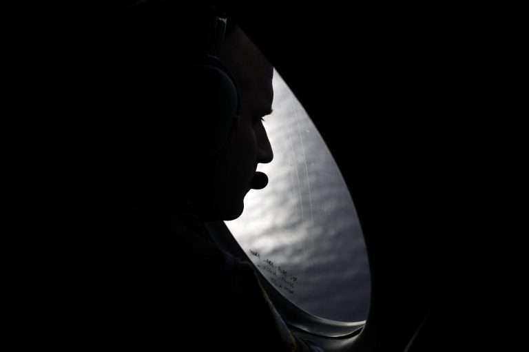 A Royal New Zealand Air Force crew member looks into the southern Indian Ocean from a P-3K2 Orion aircraft searches for missing Malaysian Airlines flight 370, Saturday, March 29, 2014. A day after the search for the Malaysian jetliner shifted to a new area of the Indian Ocean, ships on Saturday plucked objects from the sea to determine whether they were related to the missing jet. None were confirmed to be from the plane, leaving searchers with no sign of the jet three weeks after it disappeared. (AP Photo/Jason Reed, Pool)