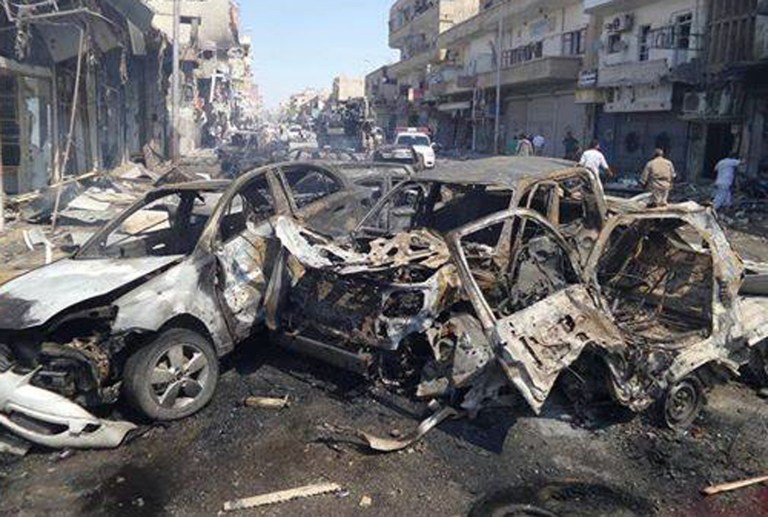 This image posted by the Raqqa Media Center of the Islamic State group, a militant extremist group, which has been authenticated based on its contents and other AP reporting, shows damaged cars that were burned after a Syrian government airstrike in the northeastern city of Raqqa, Syria, Saturday, Sept. 6, 2014. Syria launched a series of airstrikes targeting Raqqa on Saturday, killing dozens of people, most of whom died when one of the missiles slammed into a crowded bakery, activists said. The airstrikes smashed parts of buildings, set cars alight and crushed people under rubble. (AP Photo/Raqqa Media Center of the Islamic State group)