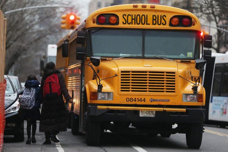 Students walk to board a school bus in Manhattan's East Village on January 15, 2013 in New York City. (Photo by Mario Tama/Getty Images)