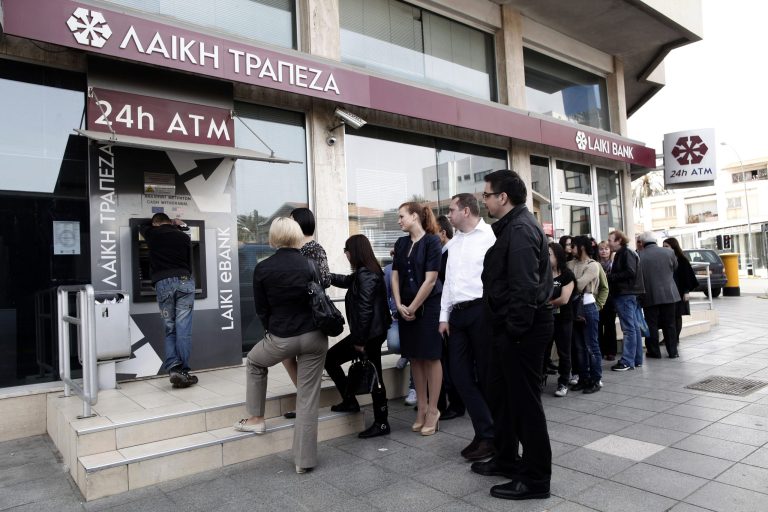 People queue at an ATM outside a closed Laiki Bank branch in capital Nicosia, Cyprus, Thursday, March 21, 2013. The European Central Bank says it will keep emergency aid for Cyprus' troubled banks in place at least until Monday but will have to cut it off after that unless an international rescue program is drawn up. (AP Photo/Petros Giannakouris)