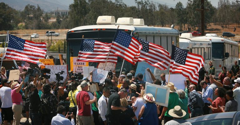 Protesters turn back three buses carrying 140 immigrants as they attempt to enter the Murrieta U.S. Border Patrol station for processing on Tuesday, July 1, 2014, in Murrieta, Calif.(AP Photo/The Press-Enterprise, David Bauman)  MAGS OUT; MANDATORY CREDIT