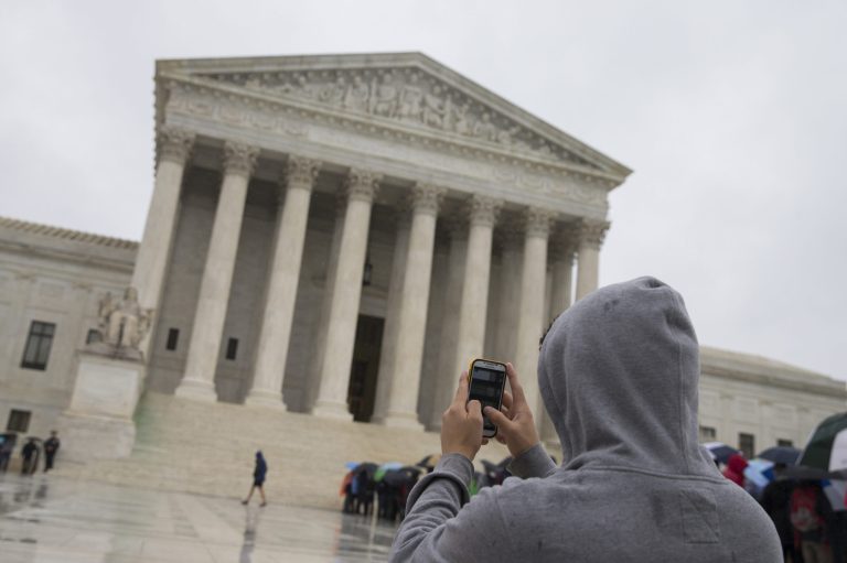 A visitor to the Supreme Court uses his cellphone to take a photo of the court in Washington. (AP Photo, File)