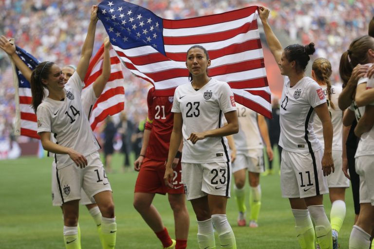 In this Sunday, July 5, 2015 file photo, United States' Morgan Brian (14), Christen Press (23), and Ali Krieger (11), celebrate with the U.S. flag after the U.S. beat Japan 5-2 in the FIFA Women's World Cup soccer championship in Vancouver, British Columbia, Canada. (AP Photo/Elaine Thompson, File)