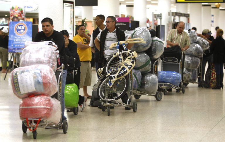   FILE - In this Dec. 19, 2011, file photo, travelers wait in line with their luggage at Miami International Airport before traveling Cuba in Miami. The door for travel to Cuba cracked open during President Barack Obama's first term. Cuban-Americans can now visit family on the island as often as they like. Americans can travel legally as part of an academic or religious trip. Perhaps it's for this reason that Obama's standing with the Cuban-American community in Florida stayed largely steady on Election Day, even though the modest openings with Cuba have riled some of South Florida's more conservative exiles. Exit polling showed that 49 percent of Cuban-Americans voted for the Democrat, roughly the same percentage as four years ago. (AP Photo/Lynne Sladky, File)  