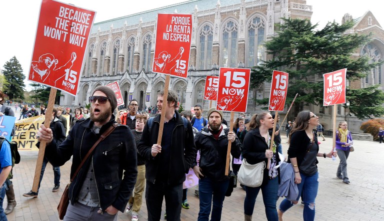 In this April 1, 2015, file photo, students and other supporters protest on the University of Washington campus in Seattle, in support of raising the minimum wage for campus workers to $15 an hour. Seattle's $15-an-hour minimum wage law has cost the city jobs, according to a study released Monday, June 26, 2017, that contradicted another new study published the week before.
