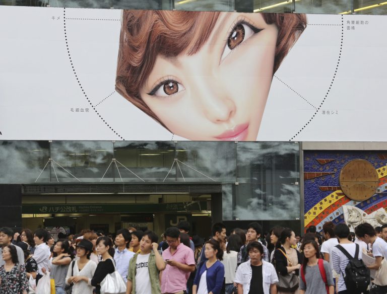 Pedestrians wait to cross a street at Shibuya shopping district in Tokyo, Friday, Aug. 29, 2014. Japan's vital signs remained weak in July as wages fell further and household spending dropped, signaling continued weakness in the world's third-largest economy. Data released Friday showed the inflation rate was unchanged from the previous month. The core price consumer index that excludes volatile fresh food prices rose 3.3 percent in July, the same as a month earlier. (AP Photo/Koji Sasahara)