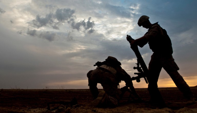 A Coalition member hangs an 81-millimeter mortar prior to launching it at a known ISIS location near the Iraqi-Syrian border. The Coalition provided fire support and air strikes to assist the Syrian Democratic Forces as they continued Operation Roundup, the military offensive to destroy ISIS east of the Euphrates River. 