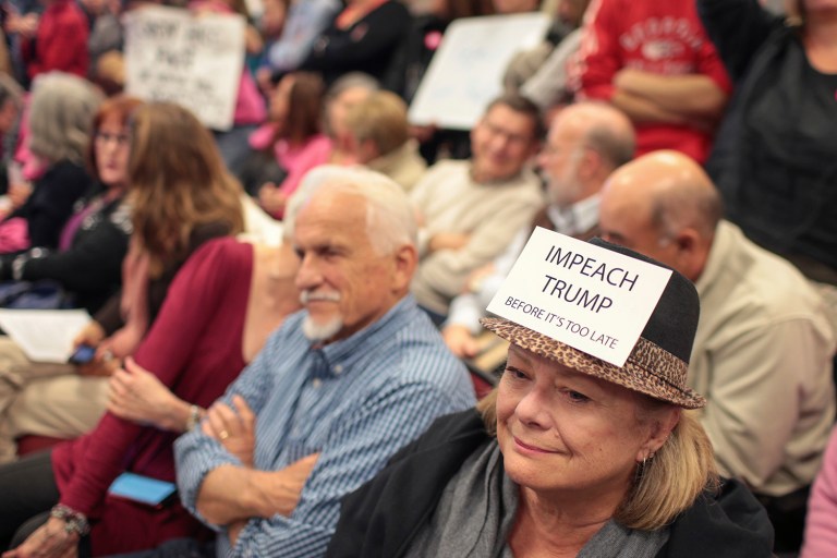 Lynn Meek wears a President Trump protest sign during an open meeting for citizens to voice their concerns to representatives from Sens. Johnny Isakson and David Perdue as well as representatives from Rep. Jody Hice's office in Greensboro, Ga. (John Roark/Athens Banner-Herald via AP)