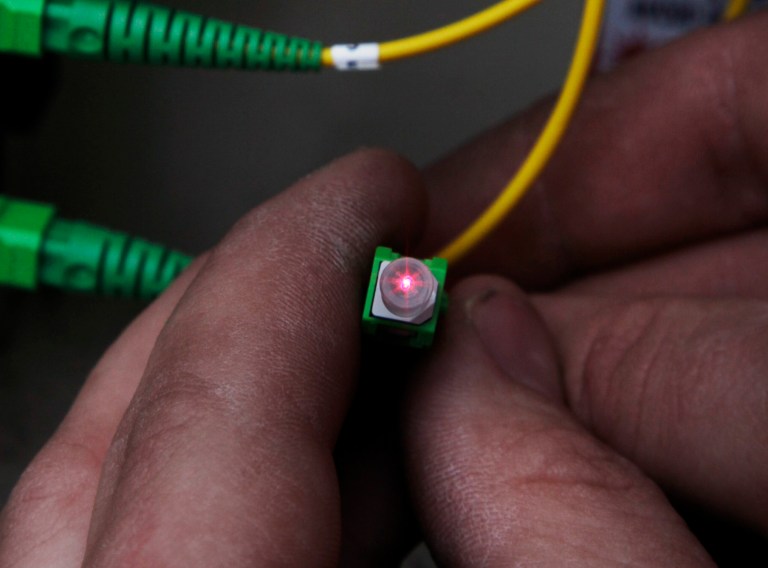 FILE - In this March 13, 2009 file photo, Tyson Hoffman, a Verizon service technician, checks a cable as he connects it to the Verizon FiOS fiber network in Rockville, Md. Verizon is boosting the upload speeds of nearly all its FiOS connections to match the download speeds, vastly shortening the time it takes for subscribers to upload videos and back up their files online, the company announced Monday, July 21, 2014. (AP Photo/Alex Brandon, File)