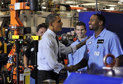 President Barack Obama, left, greets assembler Austin Ivey, right, in the turbo installation area at Detroit Diesel in Redford, Mich. on Monday, Dec. 10, 2012. Daimler AG plans to announce $100 million investment into the facility at Detroit Diesel. (AP Photo/The Detroit News, Robin Buckson, Pool)