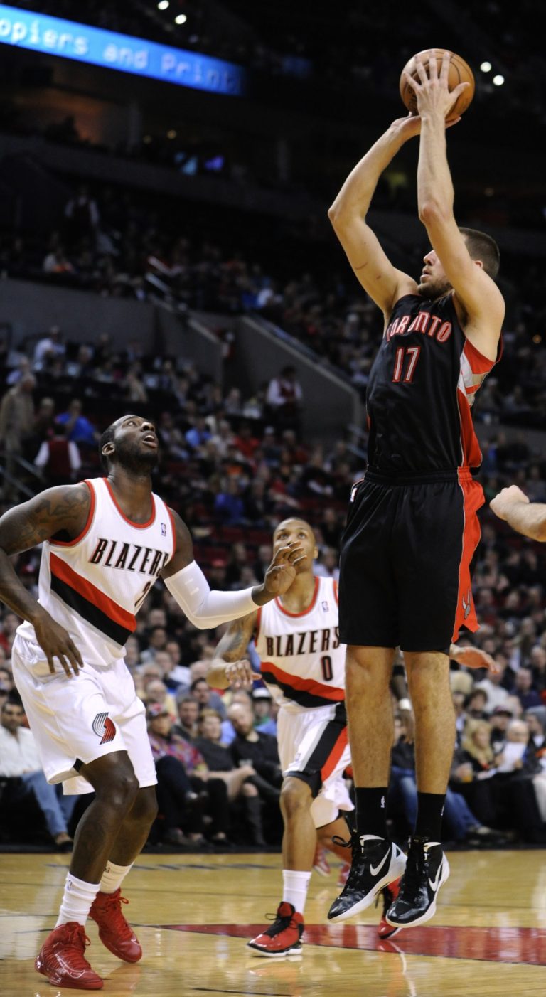   Toronto Raptors' Jonas Valanciunas (17) shoots against Portland Trail Blazers defenders J.J. Hickson, left, and Damian Lillard (0) during the first half of an NBA basketball game in Portland, Ore., Monday, Dec. 10, 2012. (AP Photo/Greg Wahl-Stephens)  