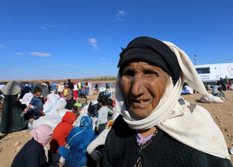 An elderly Kurdish woman looks around as Syrian refugees arrive at the Turkey-Syria border near Suruc, Turkey, Tuesday, Sept. 30, 2014 U.S.-led coalition airstrikes targeted Islamic State fighters pressing their offensive against a Kurdish town near the Syrian-Turkish border on Tuesday in an attempt to halt the militants' advance, activists said. (AP Photo/Burhan Ozbilici)