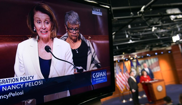 House Minority Leader Nancy Pelosi of Calif., is shown on television as she speaks from the House floor on Capitol Hill in Washington, Wednesday, Feb. 7, 2018, as a news conference that she was supposed to attend goes on in the background. (AP Photo/Susan Walsh)