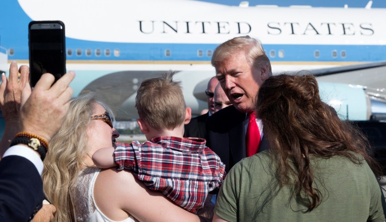 President Trump greets people on the tarmac as he arrives at Palm Beach International Airport, in West Palm Beach, Fla. Trump plans to celebrate Christmas at his Mar-a-Lago resort. (AP Photo/Carolyn Kaster)