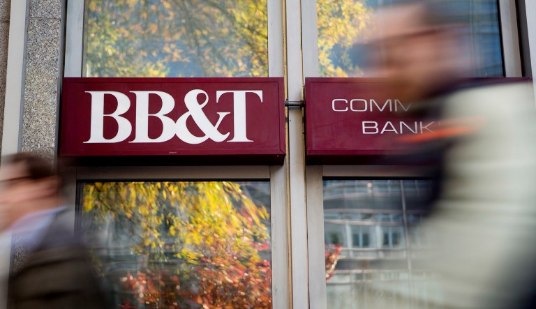 Pedestrians walk past a BB&T Corp. bank branch in Washington, D.C.