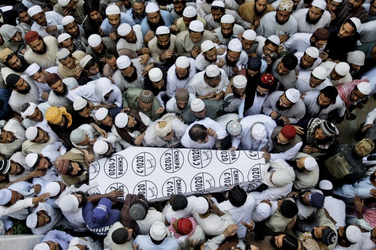   Pakistani madrassa students, gather around the coffin of Maulana Mohammad Ismail, a teacher at a Sunni seminary, who was killed by unknown gunmen, during his funeral procession in Karachi, Pakistan, Monday, Dec. 3, 2012. Violence gripped Karachi's eastern Gulshan-e-Iqbal area on Monday after unknown gunmen riding on a motorcycle shot and killed a renowned cleric and a teacher at a Sunni seminary, police said. (AP Photo/Shakil Adil)  