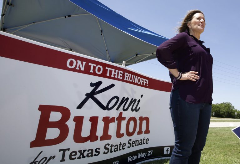 Republican Konni Burton stands in front of her campaign sign Tuesday, May 20, 2014, in Fort Worth, Texas, while campaigning for Texas State Senate. (AP Photo/Tony Gutierrez)