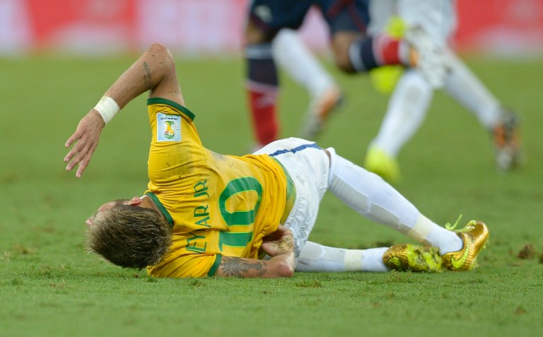 Brazil's Neymar holds his back after being fouled during the World Cup quarterfinal soccer match between Brazil and Colombia at the Arena Castelao in Fortaleza, Brazil, Friday, July 4, 2014. (AP Photo/Manu Fernandez)