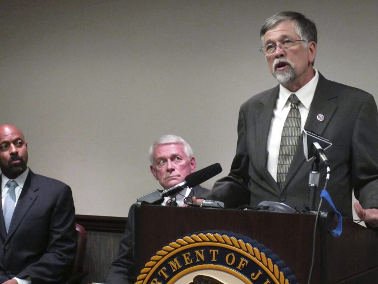 Deputy Assistant Attorney General Roy Austin, left, and U.S. Attorney for Montana Michael Cotter listen to University of Montana President Royce Engstrom discuss an agreement on the handling of campus sexual assault cases, on May 9 in Missoula, Mont. (AP Photo/Matt Gouras)