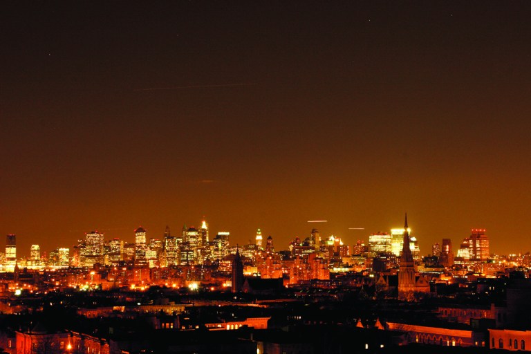 This undated image released by PBS shows the Manhattan skyline lit up at night from the documentary 