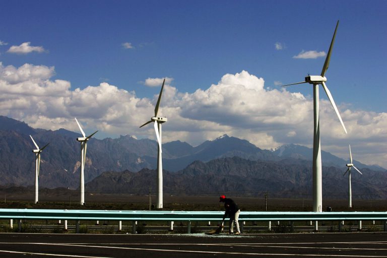 A worker sweeps a road near wind turbines at the Dafancheng Wind Power Plant, the largest of its kind in Aisa, on September 2, 2007 in Dafancheng of Xinjiang Uygur Autonomous Region, China. Â (Photo by China Photos/Getty Images)