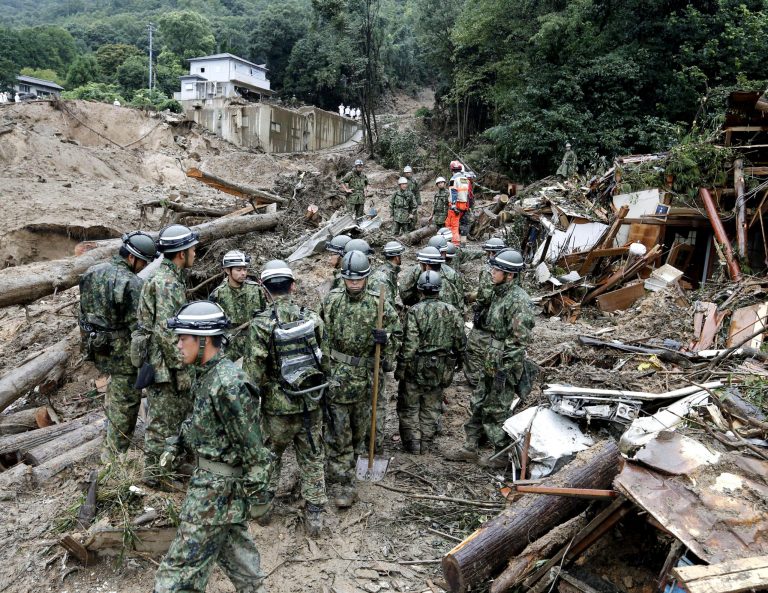 Japan's Self-Defense Force members search for survivors in the rubble in a mud-ridden residential area following a massive landslide in Hiroshima, western Japan, Friday, Aug. 22, 2014.  Hillsides caved in or were swept down into residential areas in at least five valleys in the suburbs of the western Japanese city on Wednesday, crushing dozens of houses after heavy rains.(AP Photo/Kyodo News) JAPAN OUT