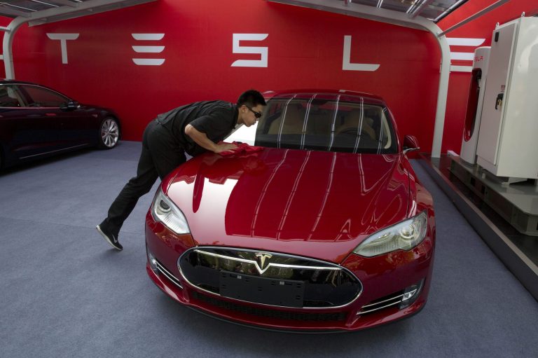 A worker cleans a Tesla Model S sedan. Company CEO Elon Musk made waves this week with a plan to take the automaker private for $420 a share. 
