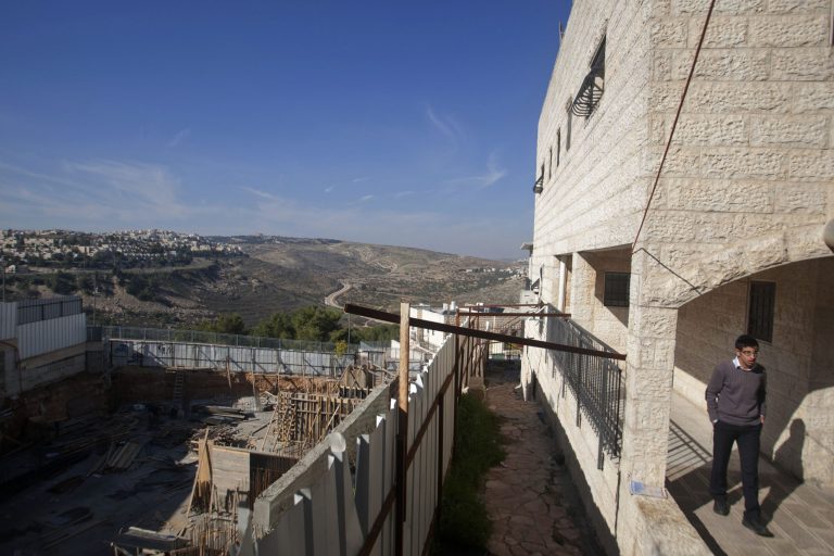   An Israeli walks near a construction site in the east Jerusalem neighborhood of Ramat Sholmo, Tuesday, Dec. 18, 2012. An European diplomat says Germany and three other European members of the U.N. Security Council are preparing a statement condemning Israel's latest settlement plans in the West Bank. (AP Photo/Dan Balilty)  