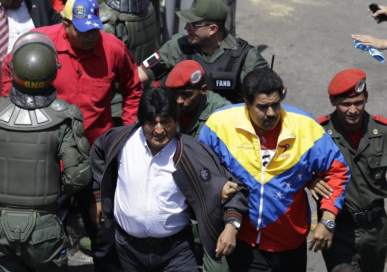 Venezuela's Vice President Nicolas Maduro, second from right, links arms with Bolivia's President Evo Morales, left, as they arrive to the Military Hospital where President Hugo Chavez died in Caracas, Venezuela, Wednesday, March 6, 2013. The coffin containing Chavez's body is being taken from the hospital to a military academy where it will remain until his funeral on Friday. Seven days of mourning were declared, all schools were suspended for the week and friendly heads of state were expected for an elaborate funeral Friday. (AP Photo/Ricardo Mazalan)