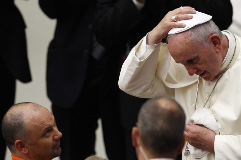 Pope Francis wears skullcaps given by faithful at the end of his weekly general audience in the Paul VI hall, at the Vatican, Wednesday, Aug. 20, 2014. (AP Photo/Riccardo De Luca)