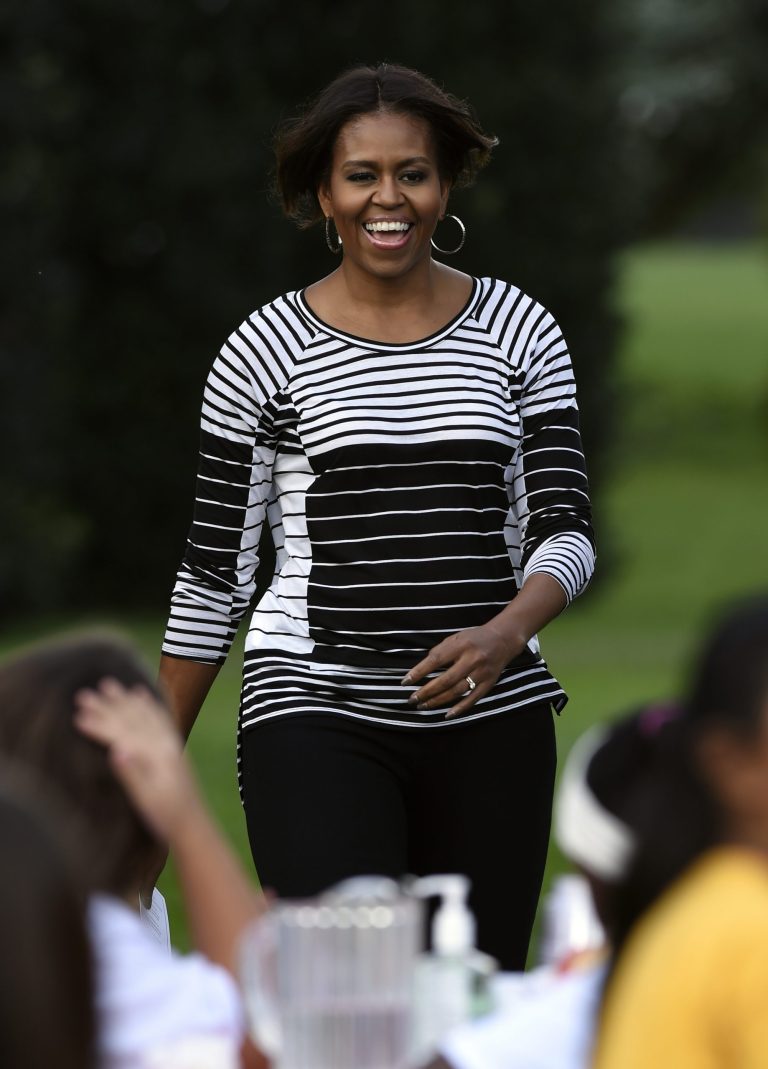 First lady Michelle Obama arrives to help with the harvest of the White House Kitchen Garden with school children at the White House in Washington, Tuesday, Oct. 14, 2014. In celebration of Farm to School Month, the Obama invited students from Arizona, California, and Ohio to participate in the fall harvest. These schools were selected because they are participating in farm to school programs that incorporate fresh, local food into their school meals, and they teach students about healthy eating through school gardens and nutrition education.(AP Photo/Susan Walsh)