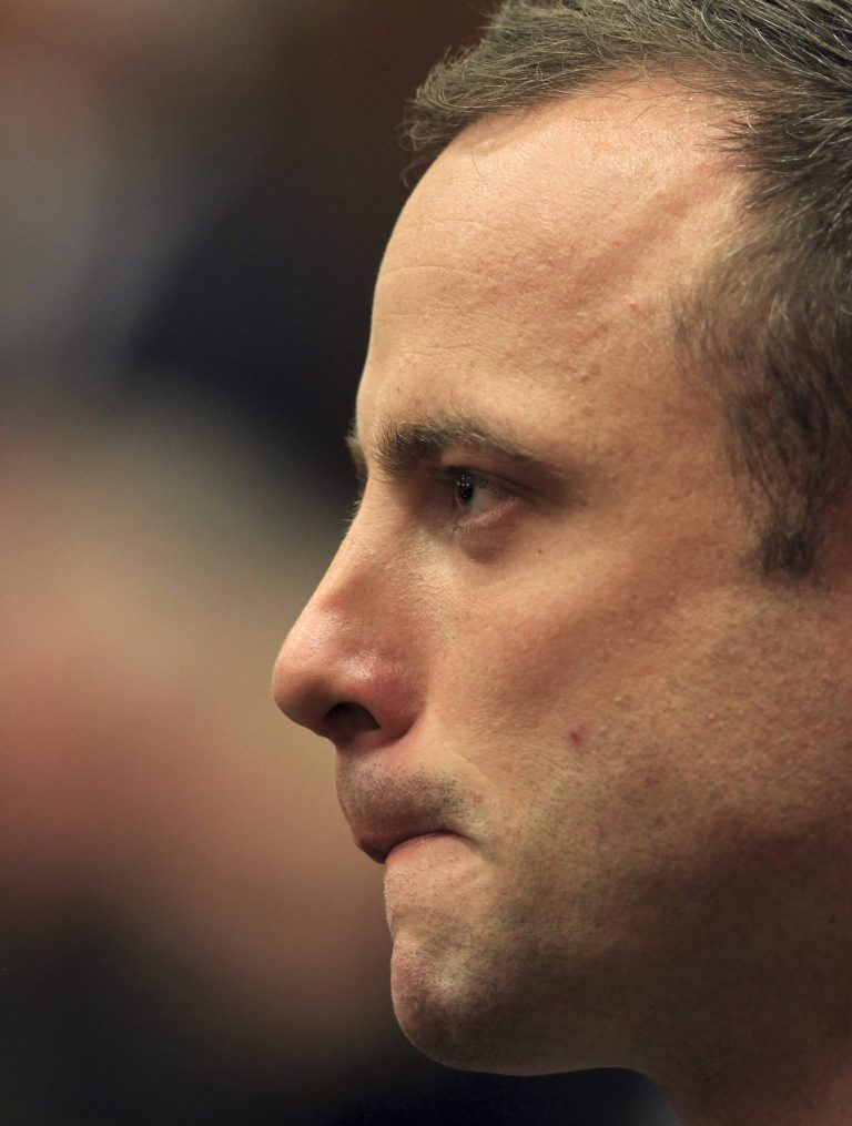 Oscar Pistorius stands in court shortly after arriving for his trial at the high court in Pretoria, South Africa, Monday, March 3, 2014. Pistorius is charged with murder with premeditation in the shooting death of girlfriend Reeva Steenkamp in the pre-dawn hours of Valentine's Day 2013.  (AP Photo/Themba Hadebe, Pool)