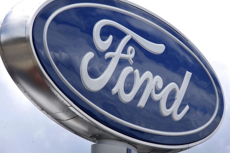 In this photo made on Thursday, June 5, 2014, clouds are reflected in the Ford sign at a dealership in Wexford, Pa. The National Highway Traffic Safety Administration says it is investigating steering problems in about 500,000 Ford cars. The investigation covers 2004 to 2007 Crown Victoria, Grand Marquis and Marauder models. (AP Photo/Keith Srakocic)