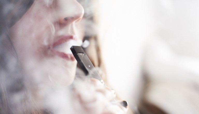A person smokes a Juul e-cigarette in this arranged photograph taken in the Brooklyn Borough of New York on Sunday, July 8, 2018.