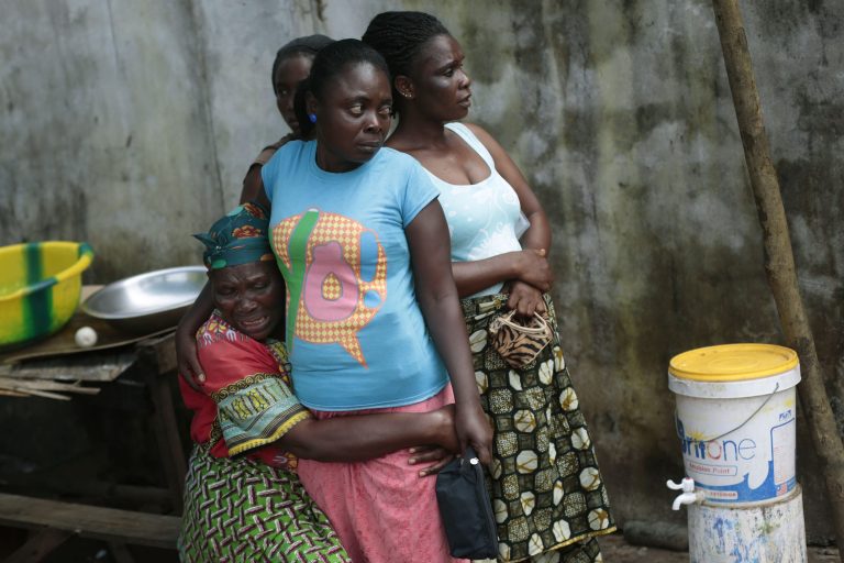 FILE - In this Friday Sept. 26, 2014 file photo, Ethel Konneh, left, is consoled by her daughters outside the Island Clinic Ebola isolation and treatment center in Monrovia, Liberia, after she learned her other daughter Rose past away from Ebola. The outbreak of Ebola has overwhelmed the weak health systems of some of the world's poorest countries: There aren't enough doctors and nurses or even clinics to treat the spiraling number of cases. (AP Photo/Jerome Delay, File)