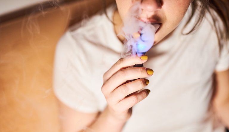 A person smokes a Juul Labs Inc. e-cigarette in this arranged photograph taken in the Brooklyn Borough of New York, U.S., on Thursday, Dec. 20, 2018.