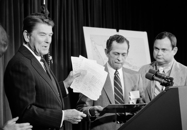 President Ronald Reagan flanked by Sen. Orrin Hatch, R-Utah, left, and Rep. Trent Lott, R-Miss. holds a Cabinet Room meeting on summer youth employment opportunities at the White House in Washington on March 25, 1985. (AP Photo/Charles Tasnadi)