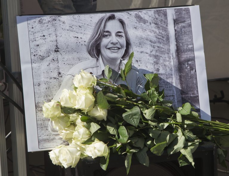 FILE - In this Saturday, April 5, 2014 file photo, roses lay in front of a picture of the Associated Press photographer Anja Niedringhaus, 48, who was killed April 4, 2014 in Afghanistan, in Paris.  Fellow officers say the Afghan police commander who killed Niedringhaus and wounded reporter Kathy Gannon seemed a calm, pious man who may have come under the influence of Islamic fundamentalists calling for vengeance against foreigners over drone strikes. (AP Photo/Michel Euler, File)