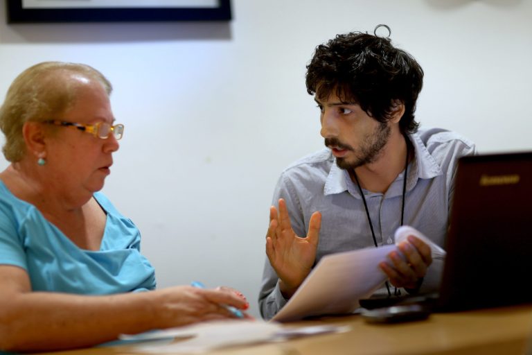 Affordable Care Act navigator Adrian Madriz speaks with Lourdes Duenas, who is looking for health insurance, during a navigation session put on by the Epilepsy Foundation Florida on Oct. 8 in Miami, Florida. (Joe Raedle/Getty Images)
