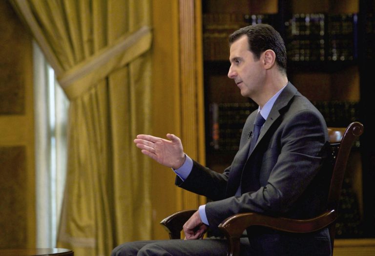 In this photo released Wednesday, March 4, 2015, by the Syrian official news agency SANA, Syrian President Bashar Assad speaks during an interview with Portuguese state television, RTP, in Damascus, Syria. Assad denied that his troops drop barrels bombs on civilians telling a journalist: 