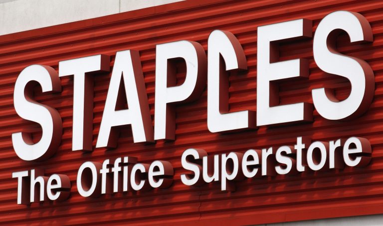 FILE - In this May 17, 2011 file photo, a Staples sign is displayed on the front of a Staple store, in Portland, Ore. Staples says it will shutter 225 North American stores, about 10 percent of Staples Inc.'s worldwide total of 2,200, by the end of 2015, and the office-supply retailer has started a plan to save about $500 million annually. (AP Photo/Rick Bowmer, File)